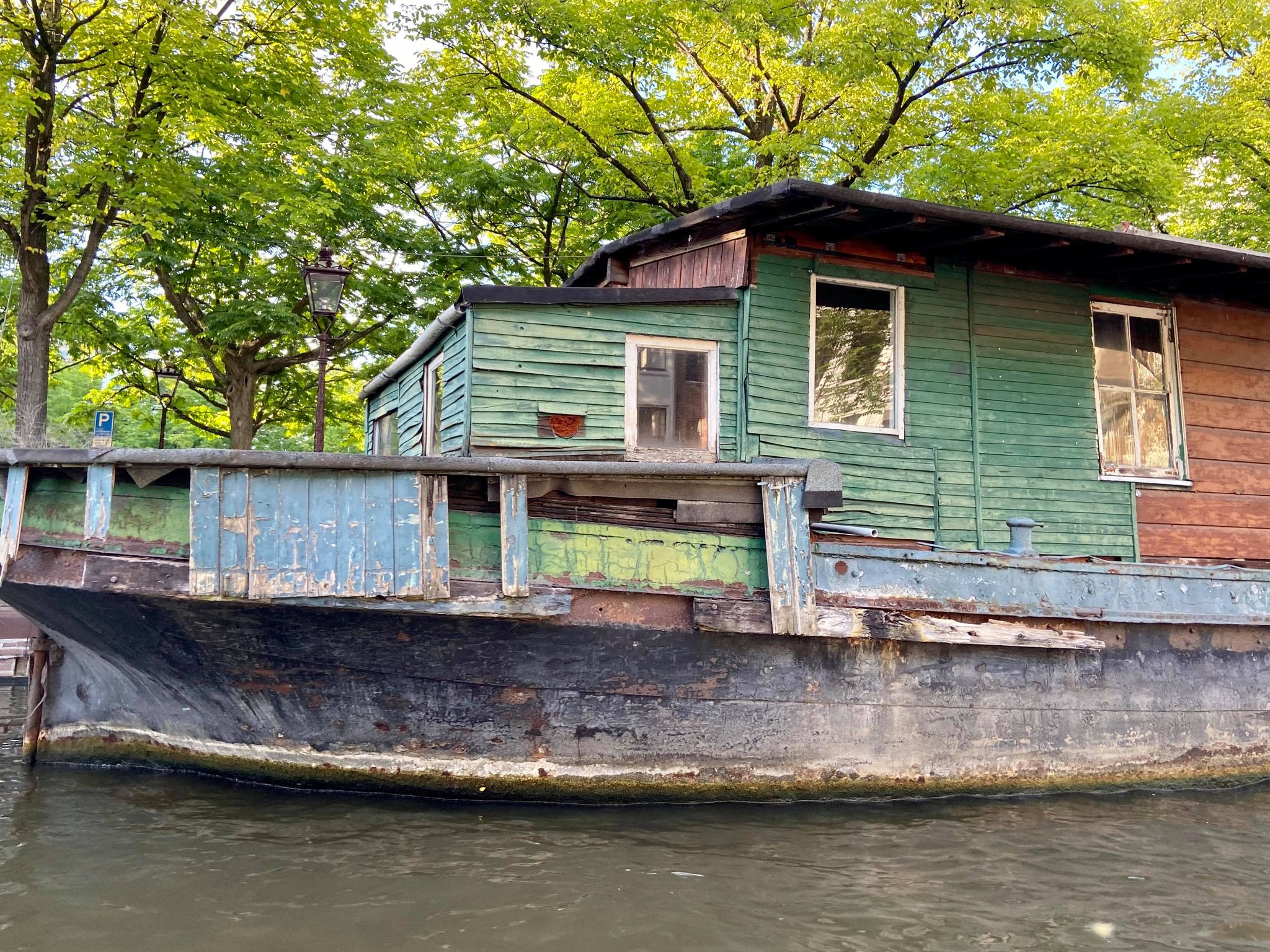 A green houseboat on a dutch canal.